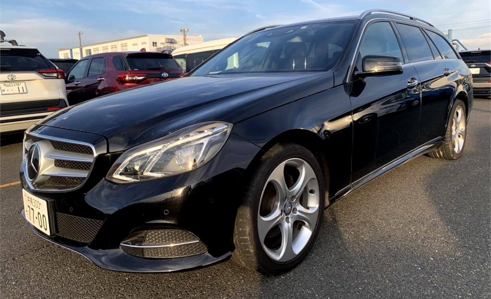A black Mercedes-Benz E-Class Wagon at a Japanese car auction.