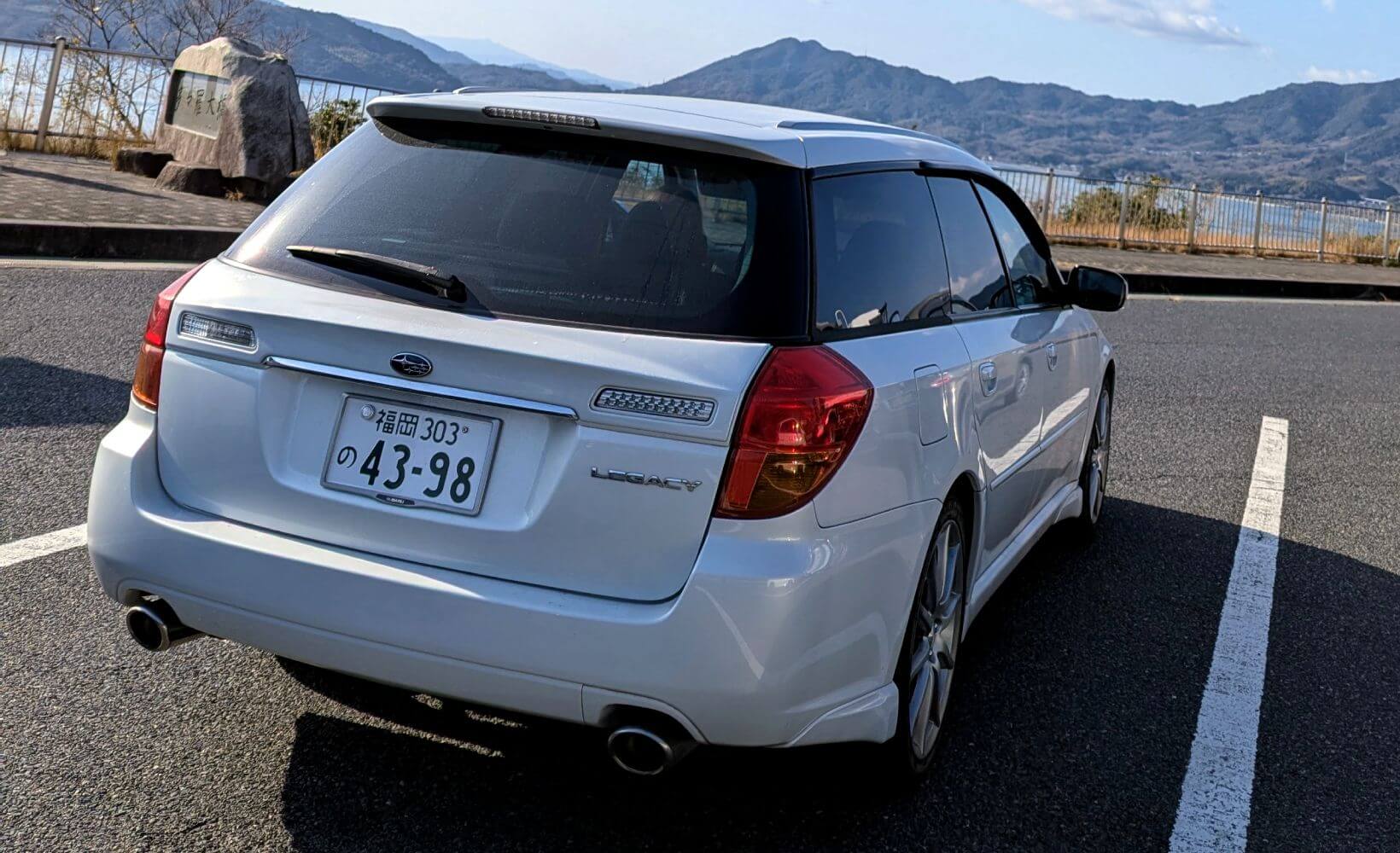 Rear view of a white Subaru Legacy Wagon in Japan.