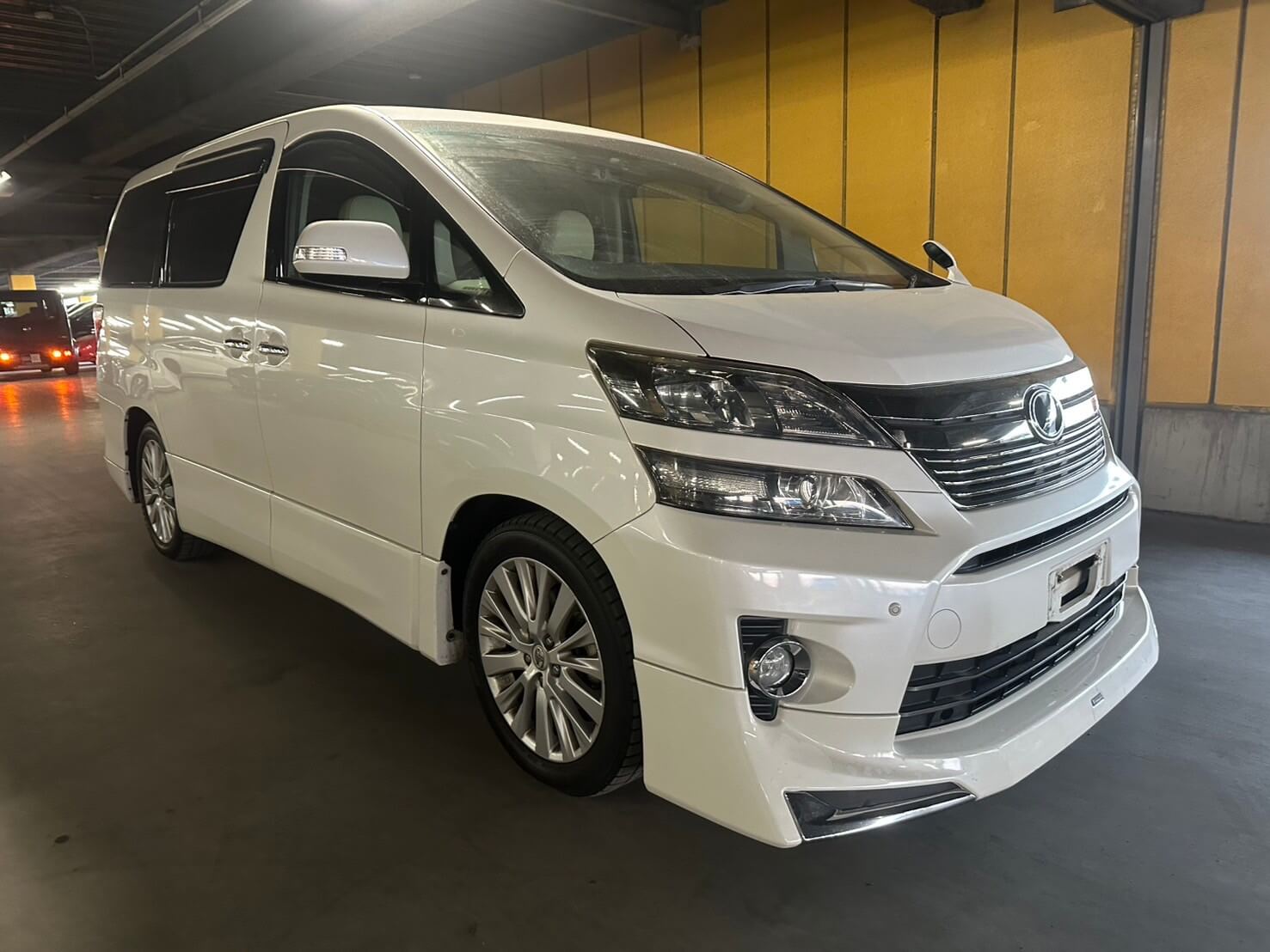 A white Toyota Vellfire family van at a Japanese used car auction